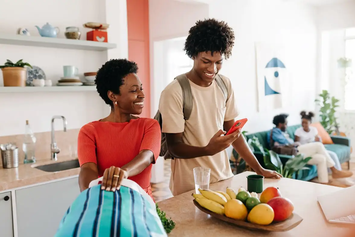 Man and woman looking at a phone in the kitchen